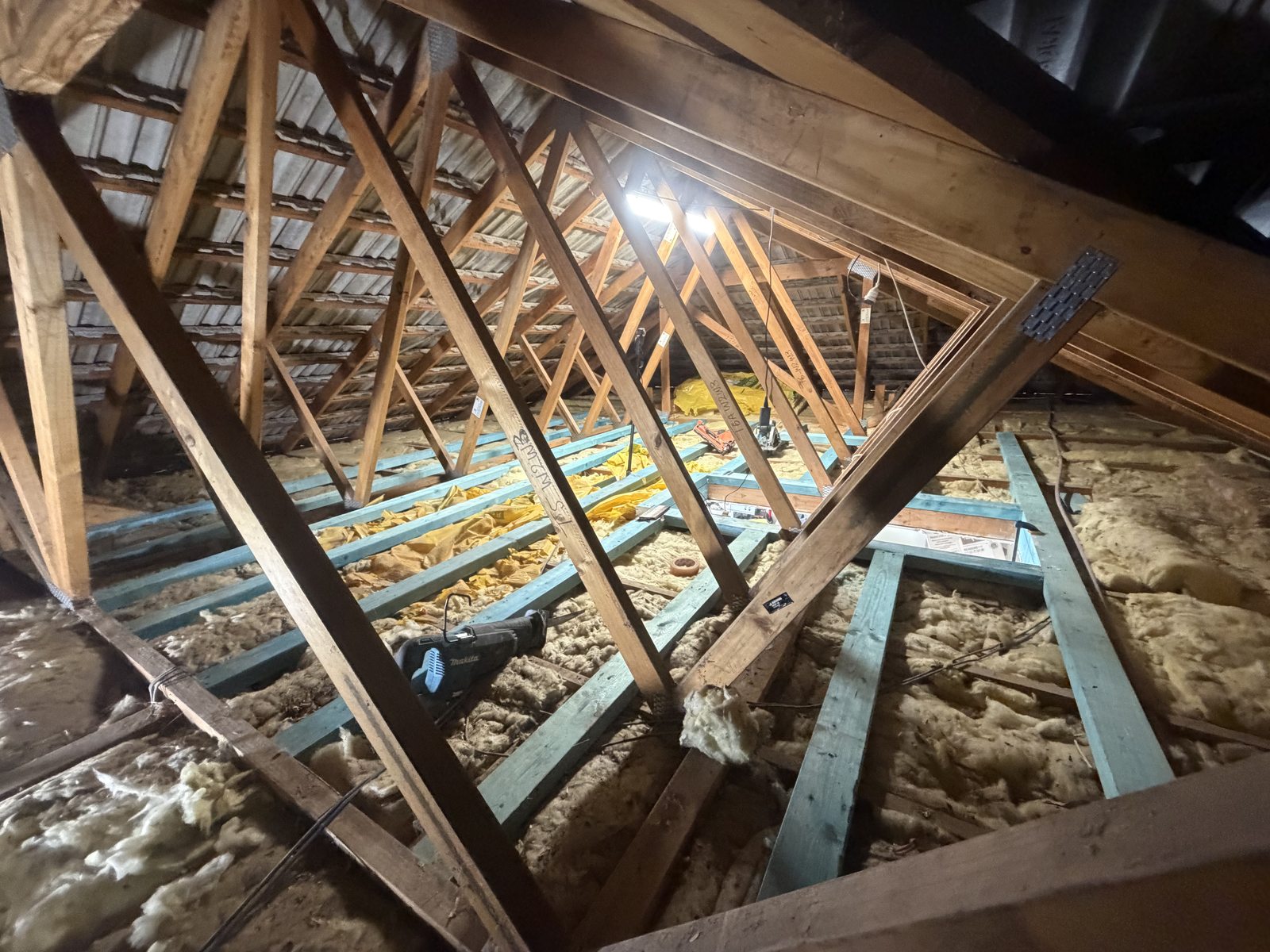 Roof space before: open trusses with insulation batts and floor bearers going in