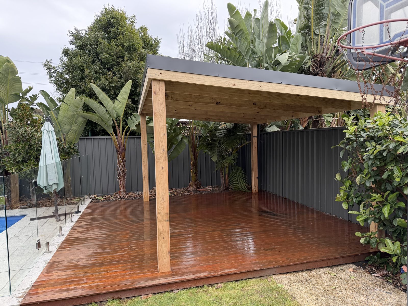 After: flat-roof pergola built over the oiled merbau deck